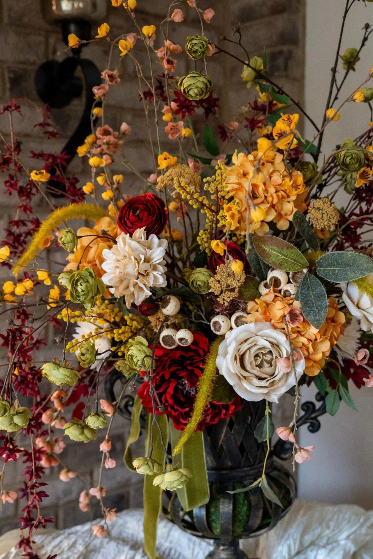 Old world floral arrangement in a black pitcher